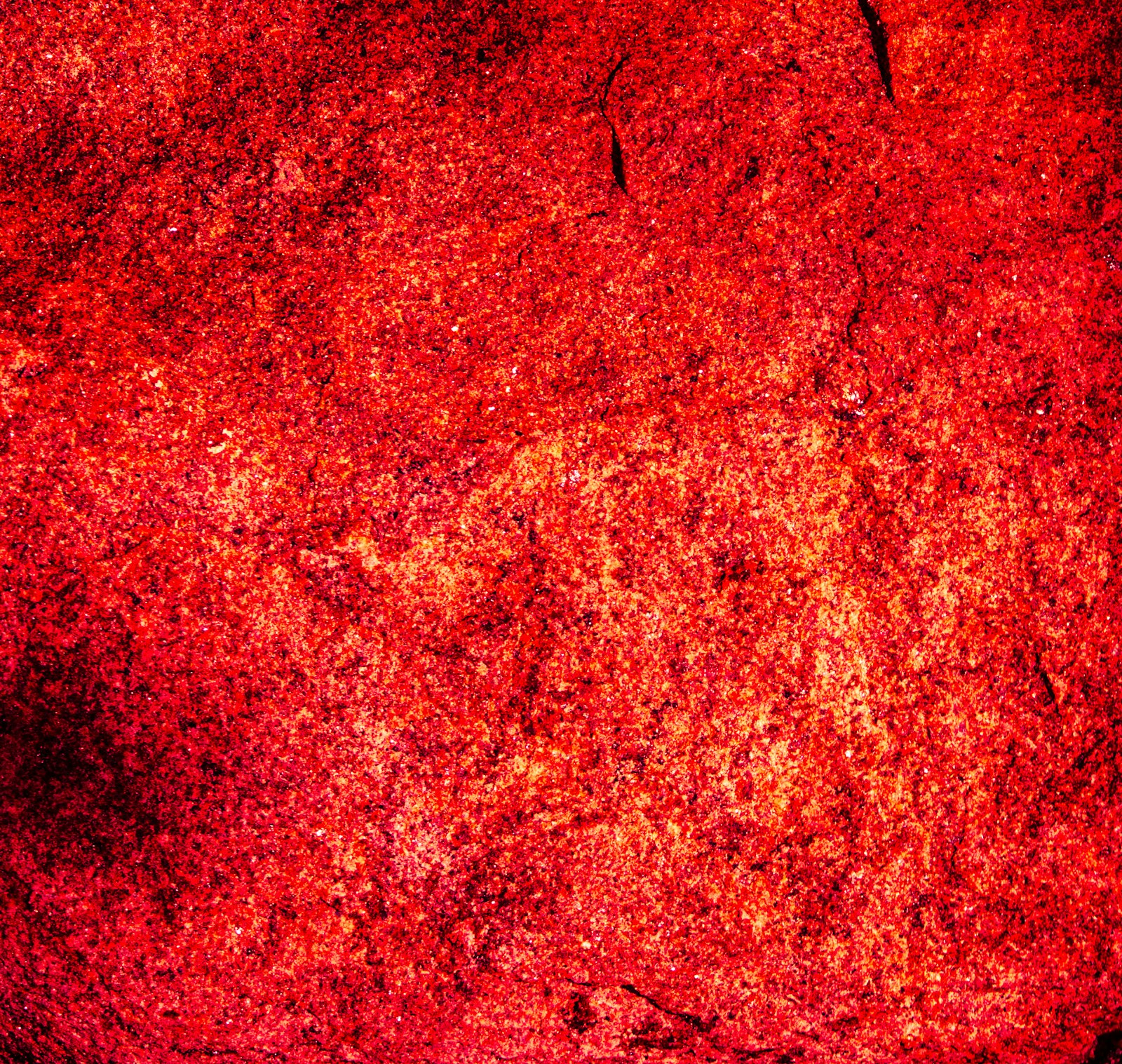 A vibrant red textured surface with rough details.